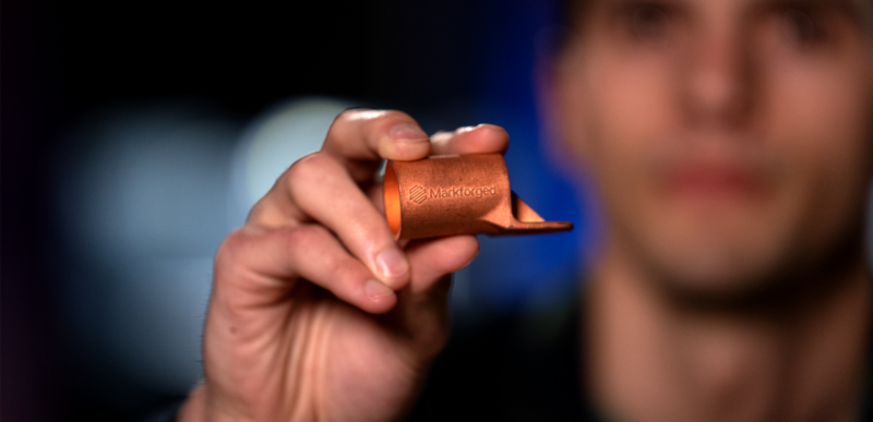 Image of Markforged Product Manager Ross Adams holding Copper busbar component.